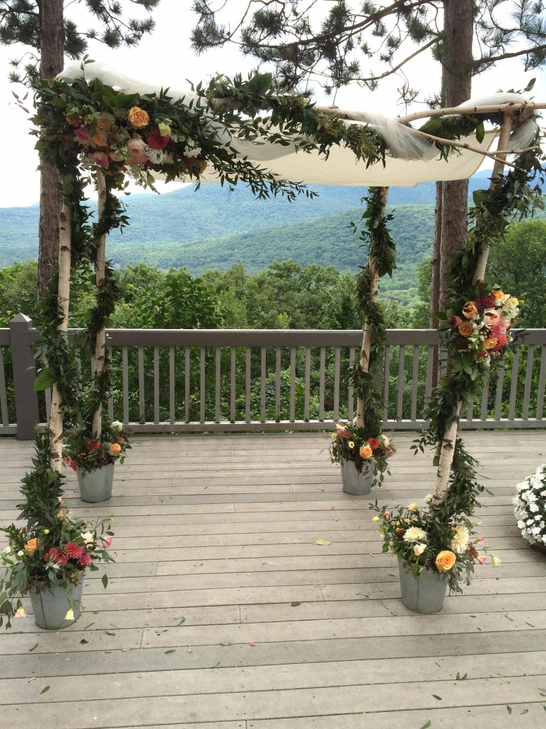 floral and vine garland around chuppah with mountain view